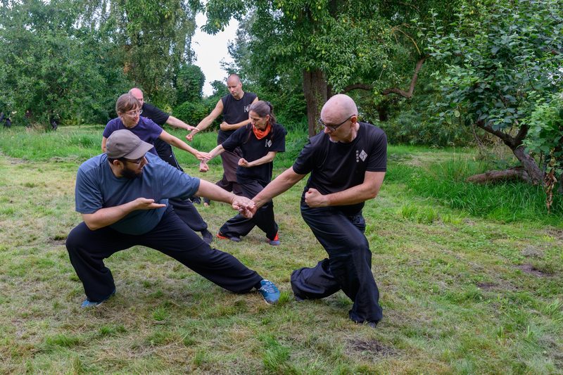 Fortgeschrittene Schüler trainieren die Tiger-Kranich-Partnerform mit Abhärtungsübungen
