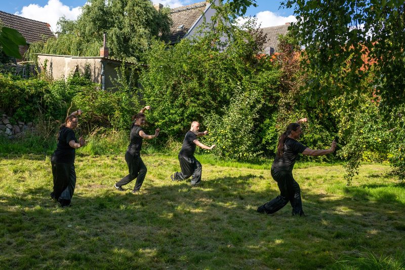 Trainingsgruppe übt die Tiger-Kranich-Form unter freiem Himmel in Loitz